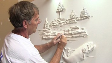 Bernie Mitchel at work, creating another unique wall sculpture from drywall compound
