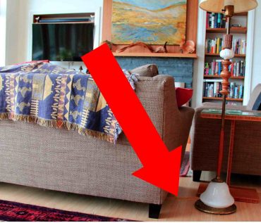 The floor lamp's wire disappears to a floor socket under the sofa