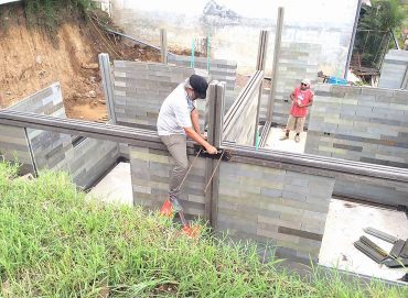 Local labor is trained to build inexpensive housing using leg-like blocks of re-molded plastic waste