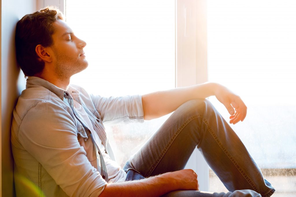 Man enjoying peace and quiet by a window